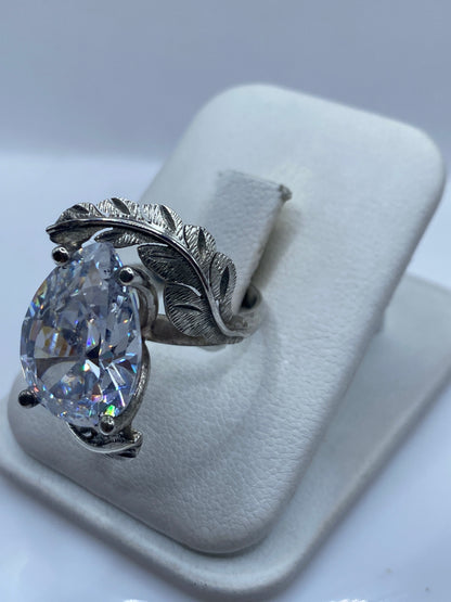 Anillo de plata con hojas artesanales talladas en relieve, detalle del engaste lateral