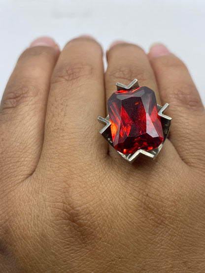 Anillo rojo solitario en dedo de mujer, mostrando el sello .925 MEXICO en la banda