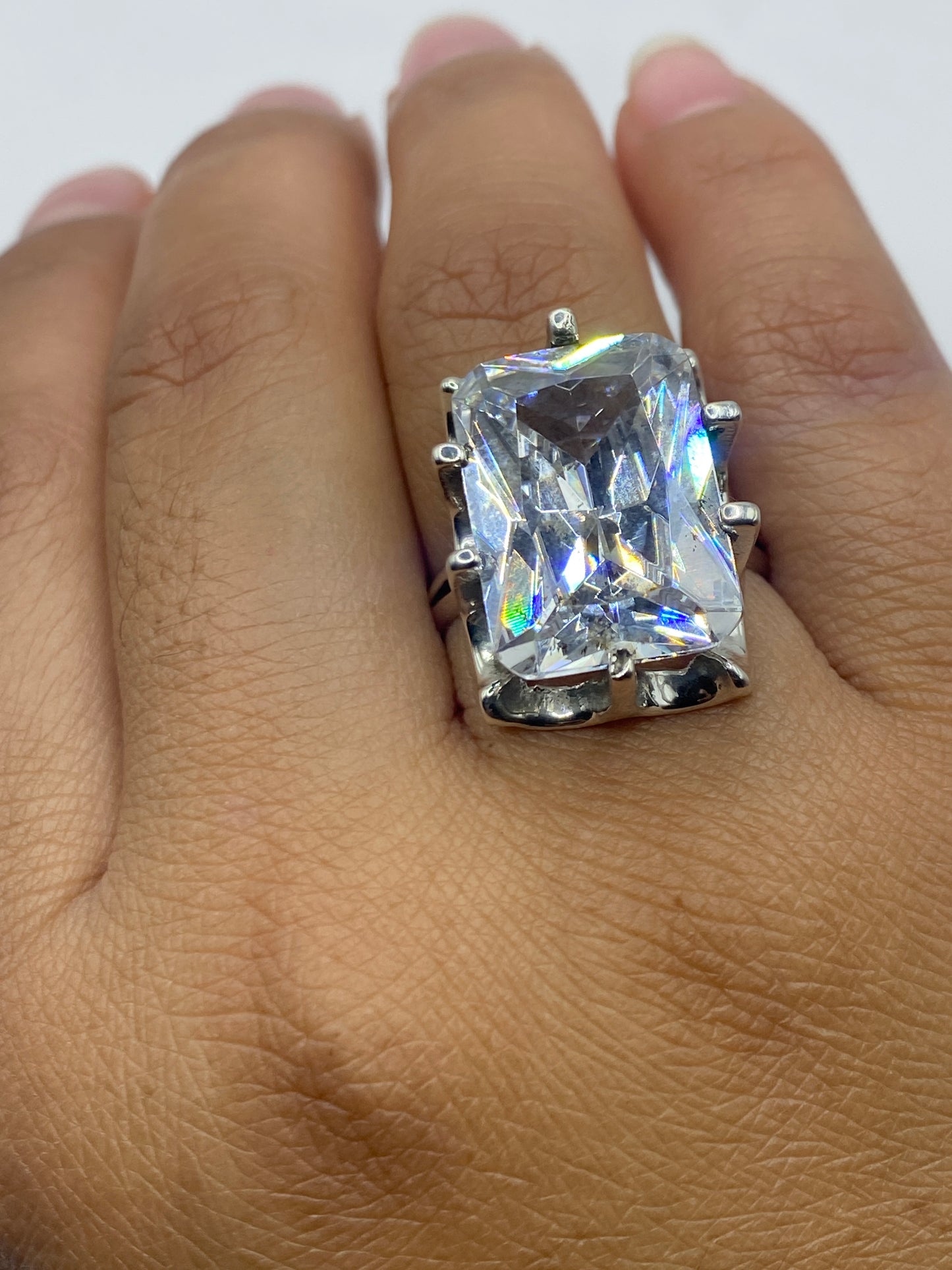 Anillo solitario en dedo mostrando brillo y fuego de la piedra blanca