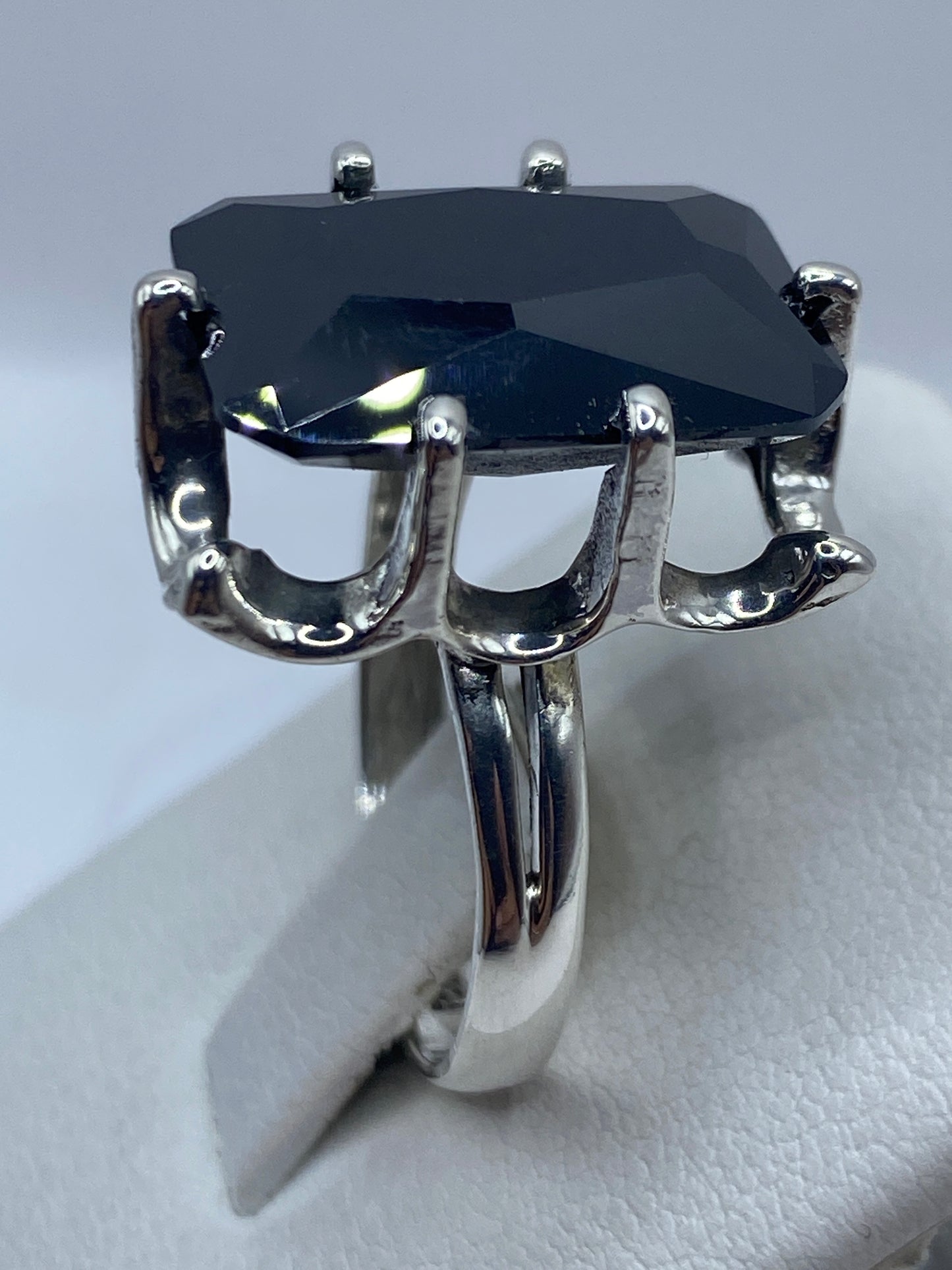 Detalle de la circonia negra facetada brillando bajo luz natural