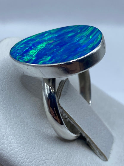Anillo ajustable de plata en la mano mostrando el fuego azul de la piedra