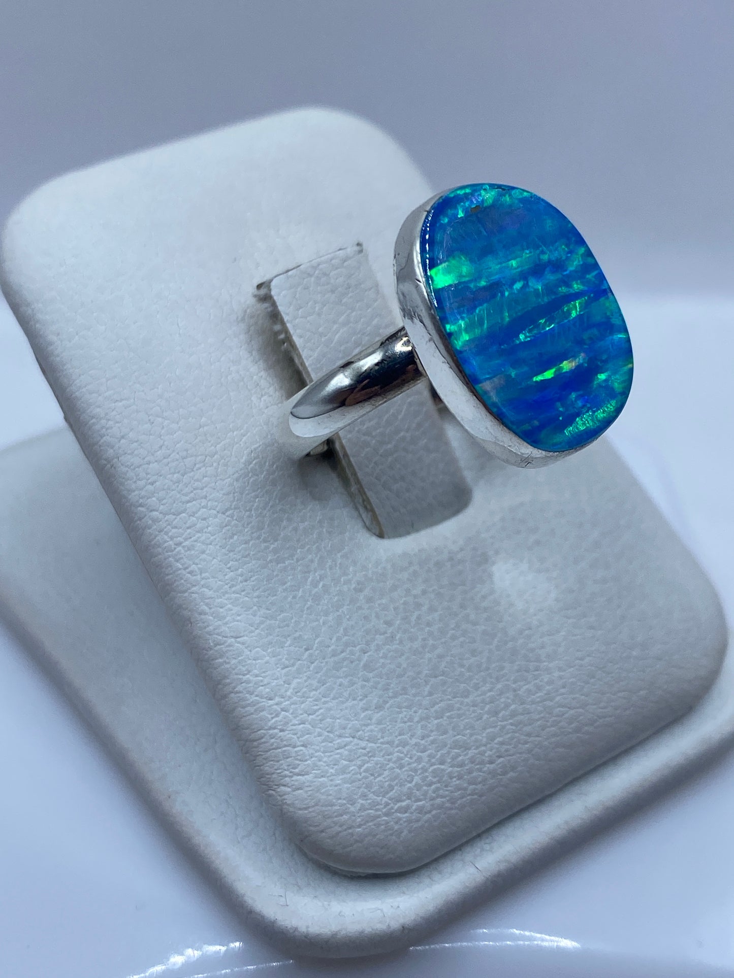 Detalle del ópalo de fuego mostrando el juego de colores azul intenso en engaste de plata .950