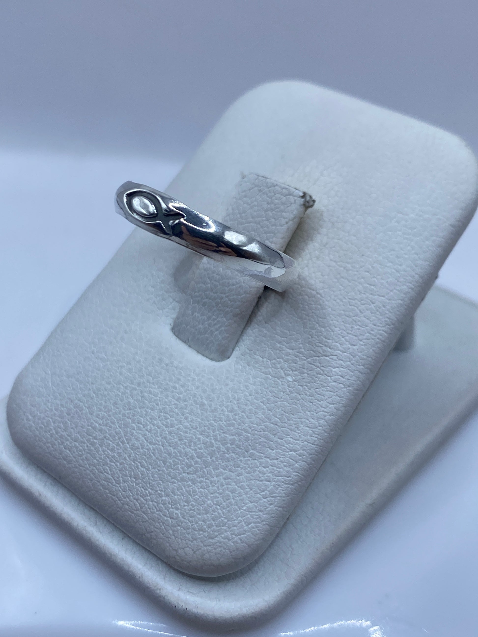 Anillo solitario de plata .925 en la mano, detalle del pulido espejo