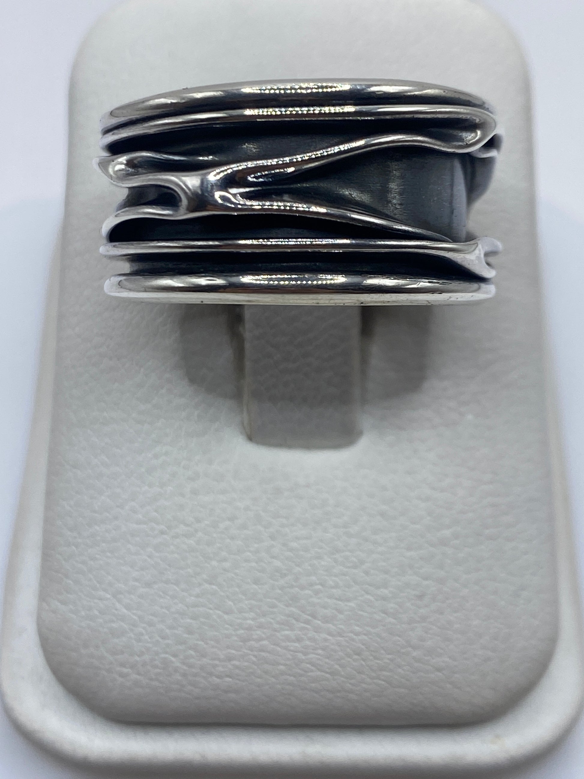 Anillo de plata con bandas superpuestas en posición horizontal sobre fondo blanco