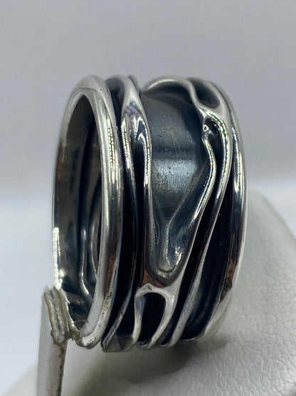 Anillo de plata puesto en dedo mostrando el movimiento visual de las bandas superpuestas