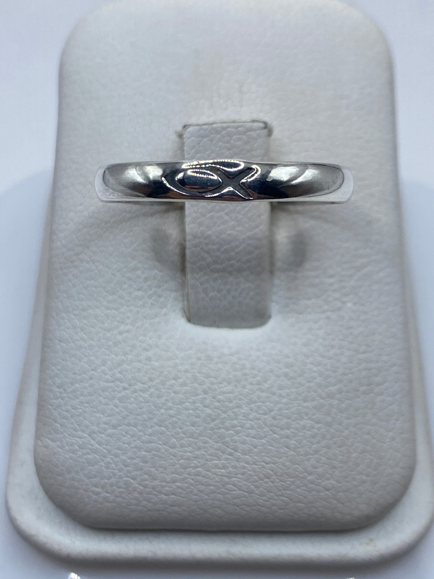 Anillo de plata banda pulida minimalista en la mano de una persona