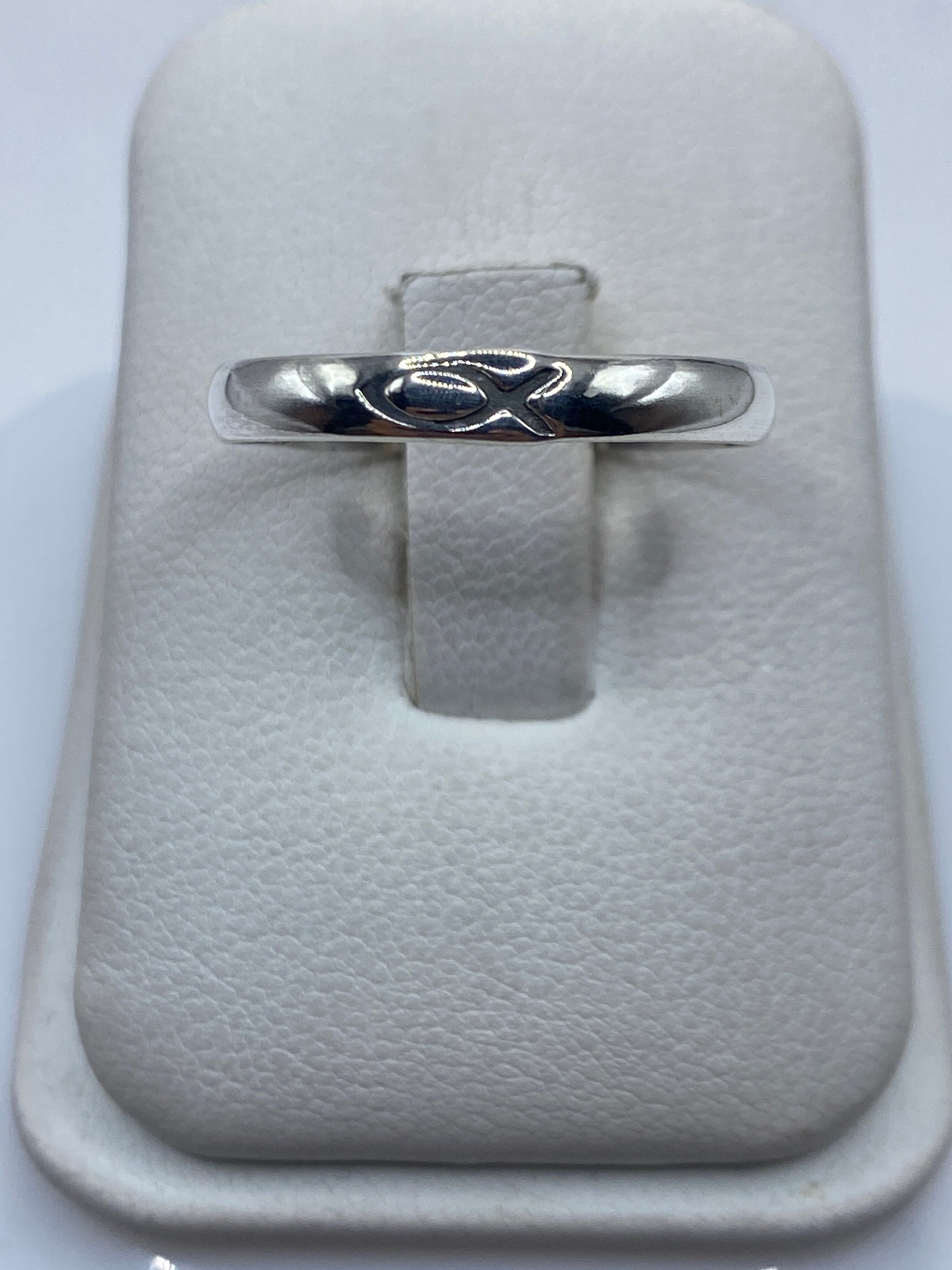 Anillo de plata banda pulida minimalista en la mano de una persona