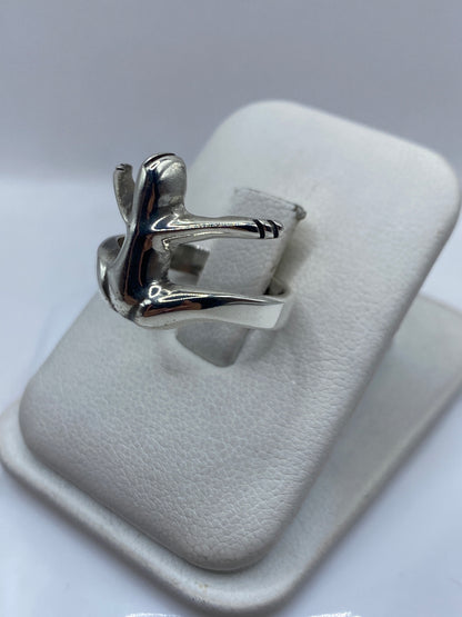 Vista lateral del anillo escultural ala en plata pulida brillante