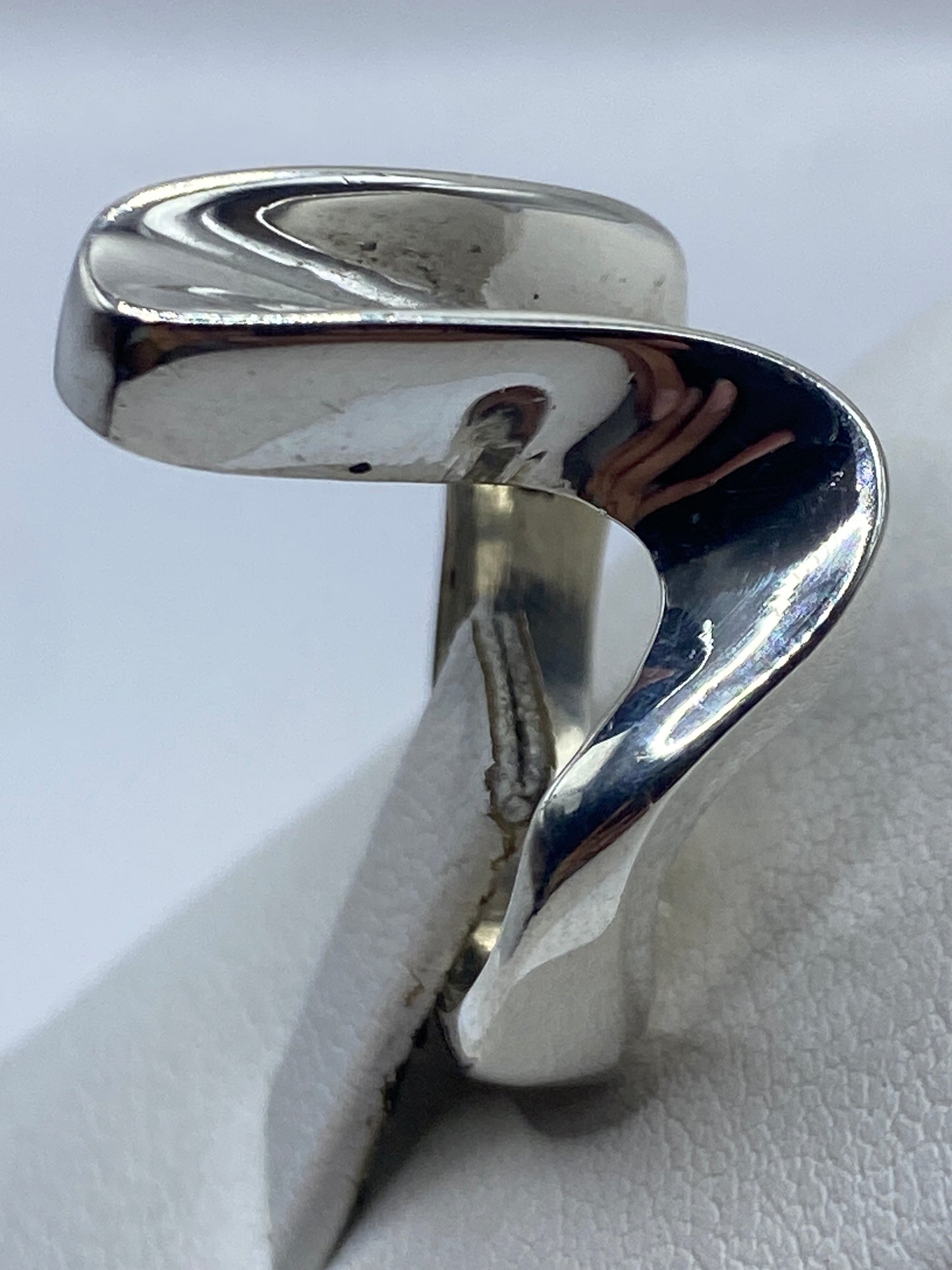 Anillo de plata .925 puesto en mano de mujer, vista frontal del diseño fluido