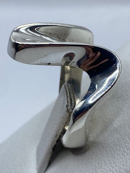 Anillo de plata .925 puesto en mano de mujer, vista frontal del diseño fluido