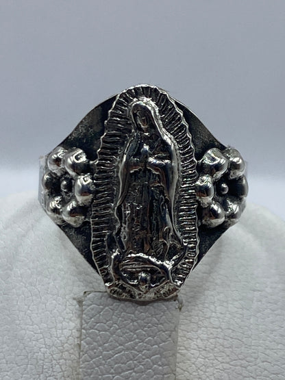 Anillo religioso puesto en dedo, mostrando el relieve del tallado