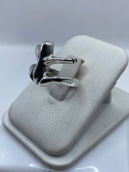 Detalle lateral del anillo mostrando las alas trabajadas a mano y la banda de plata
