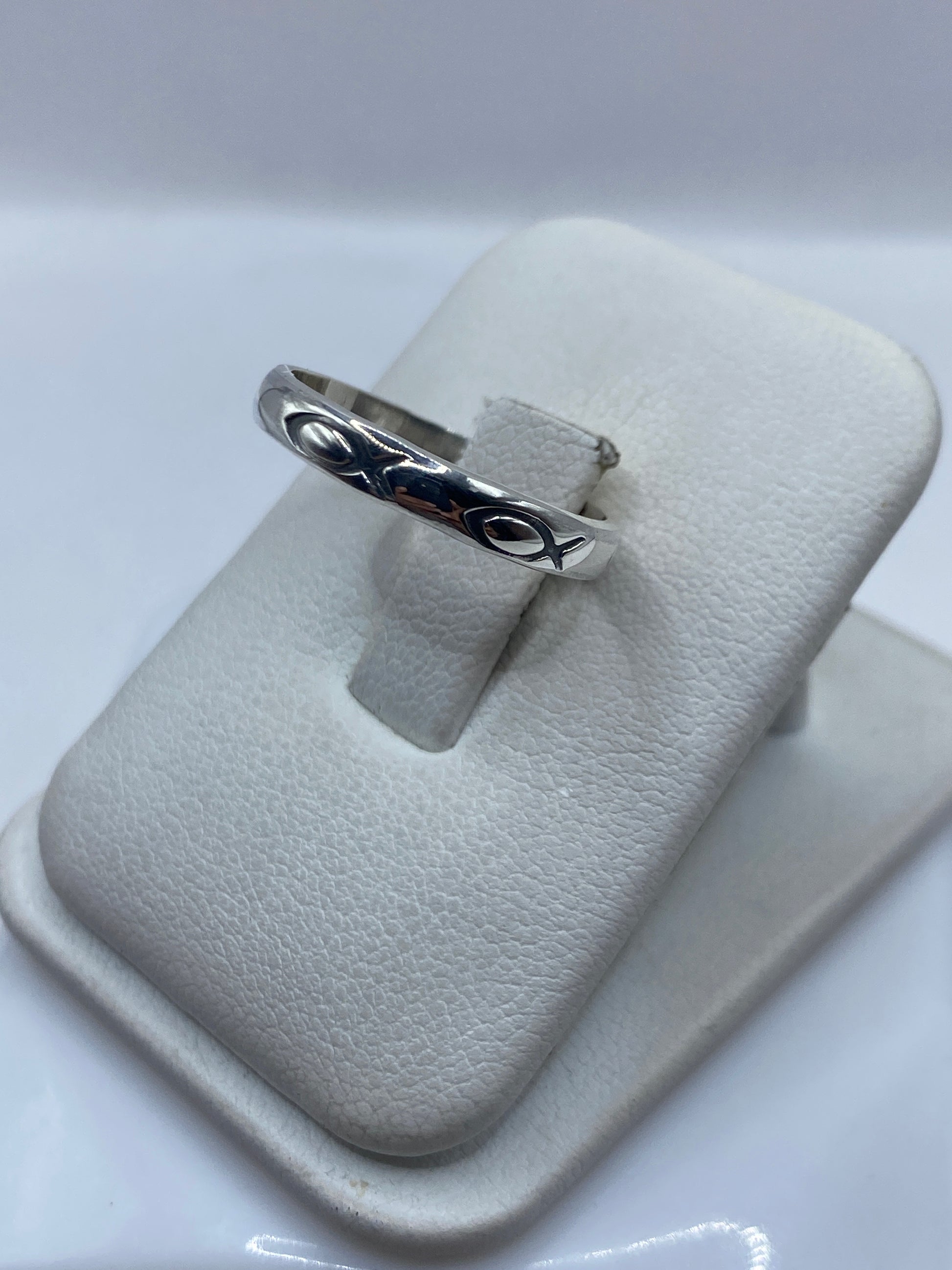 Anillo minimalista de plata en la mano, mostrando el diseño liso y pulido