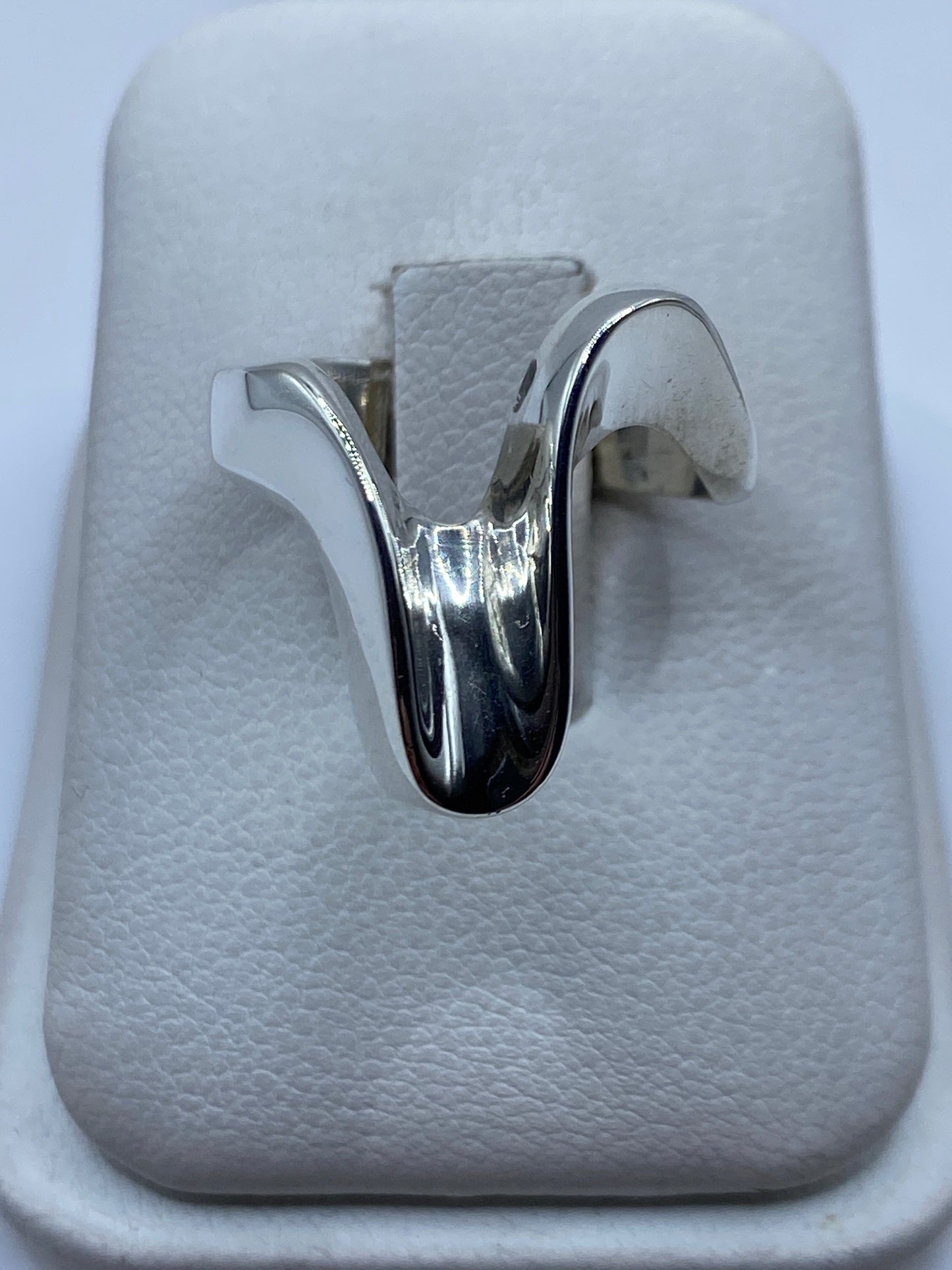 Anillo de plata pulido minimalista en dedo de mujer con acabado espejo
