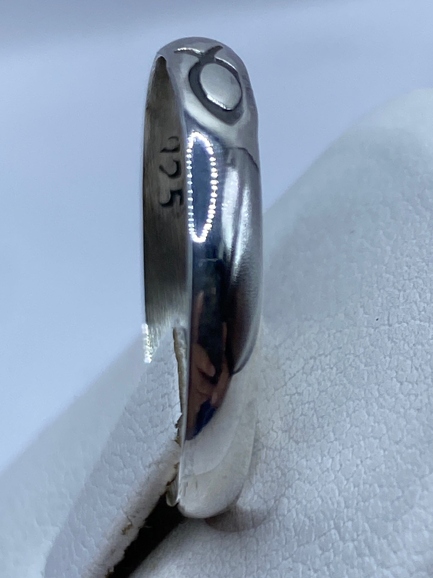 Anillo de plata puesto en dedo de mujer adulta, diseño unisex