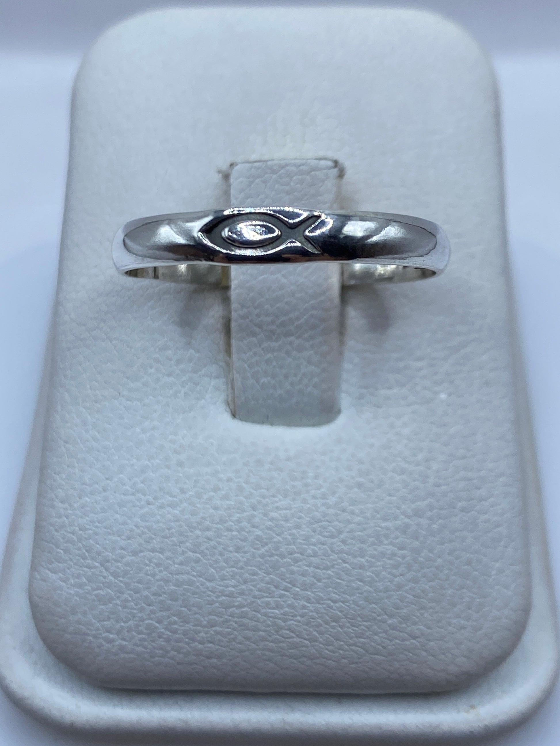 Anillo de plata sencillo pulido en talla 11, vista frontal sobre almohada blanca