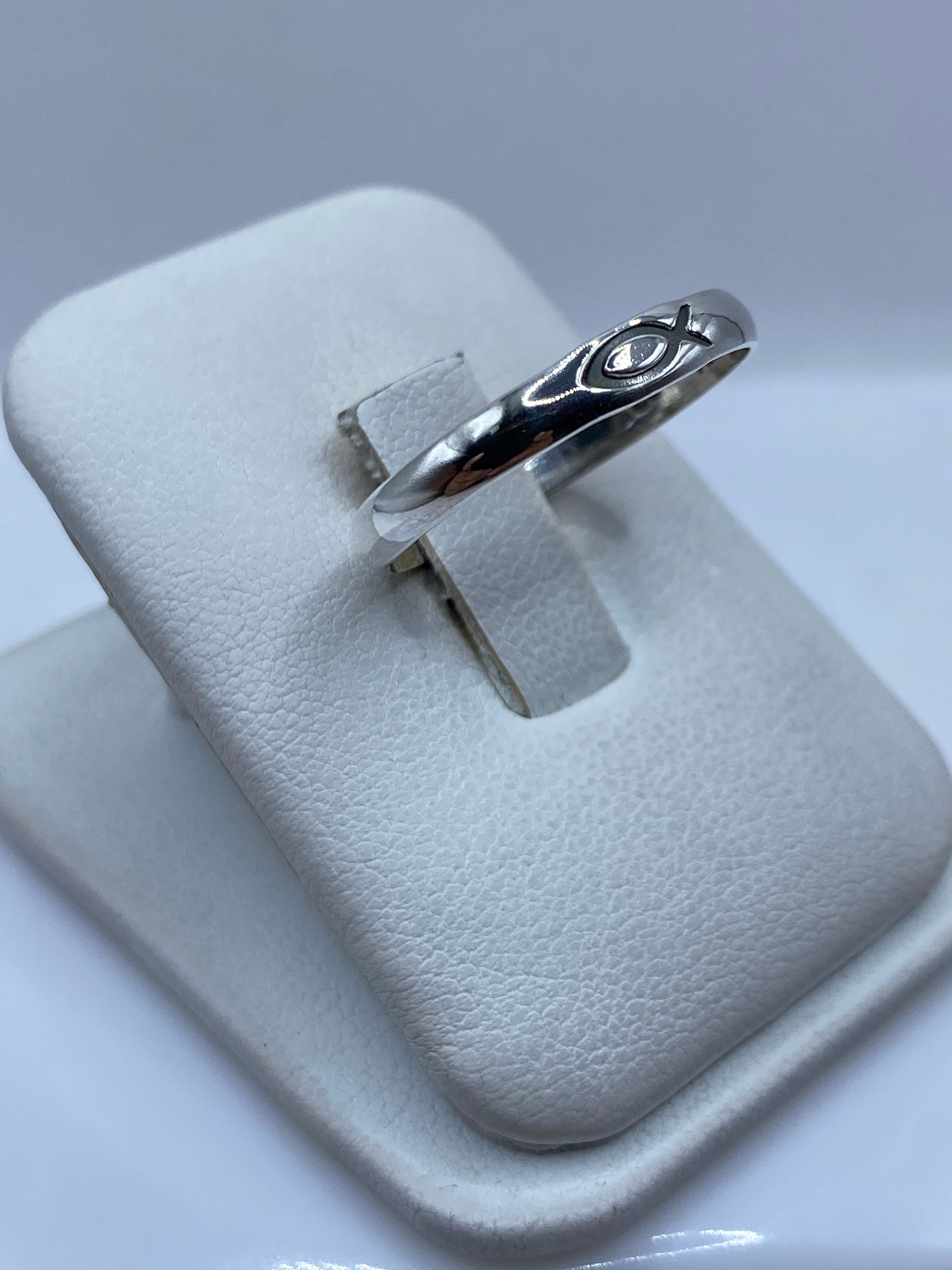 Anillo minimalista de plata .925 en el dedo de una persona, mostrando el pulido brillante