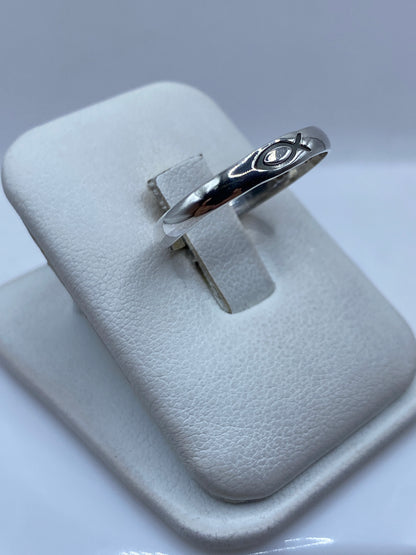 Anillo minimalista de plata .925 en el dedo de una persona, mostrando el pulido brillante