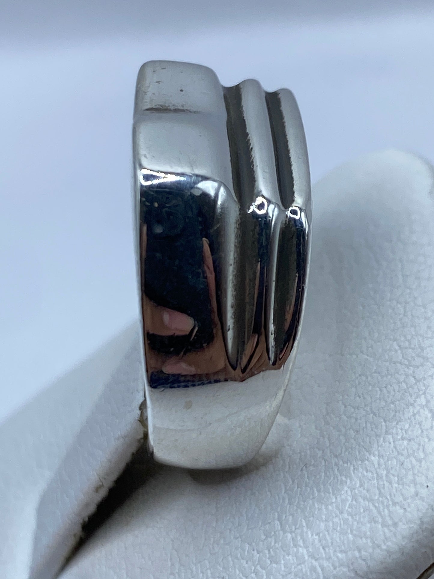 Detalle lateral del anillo mostrando las facetas pulidas y el sello 925 MEXICO