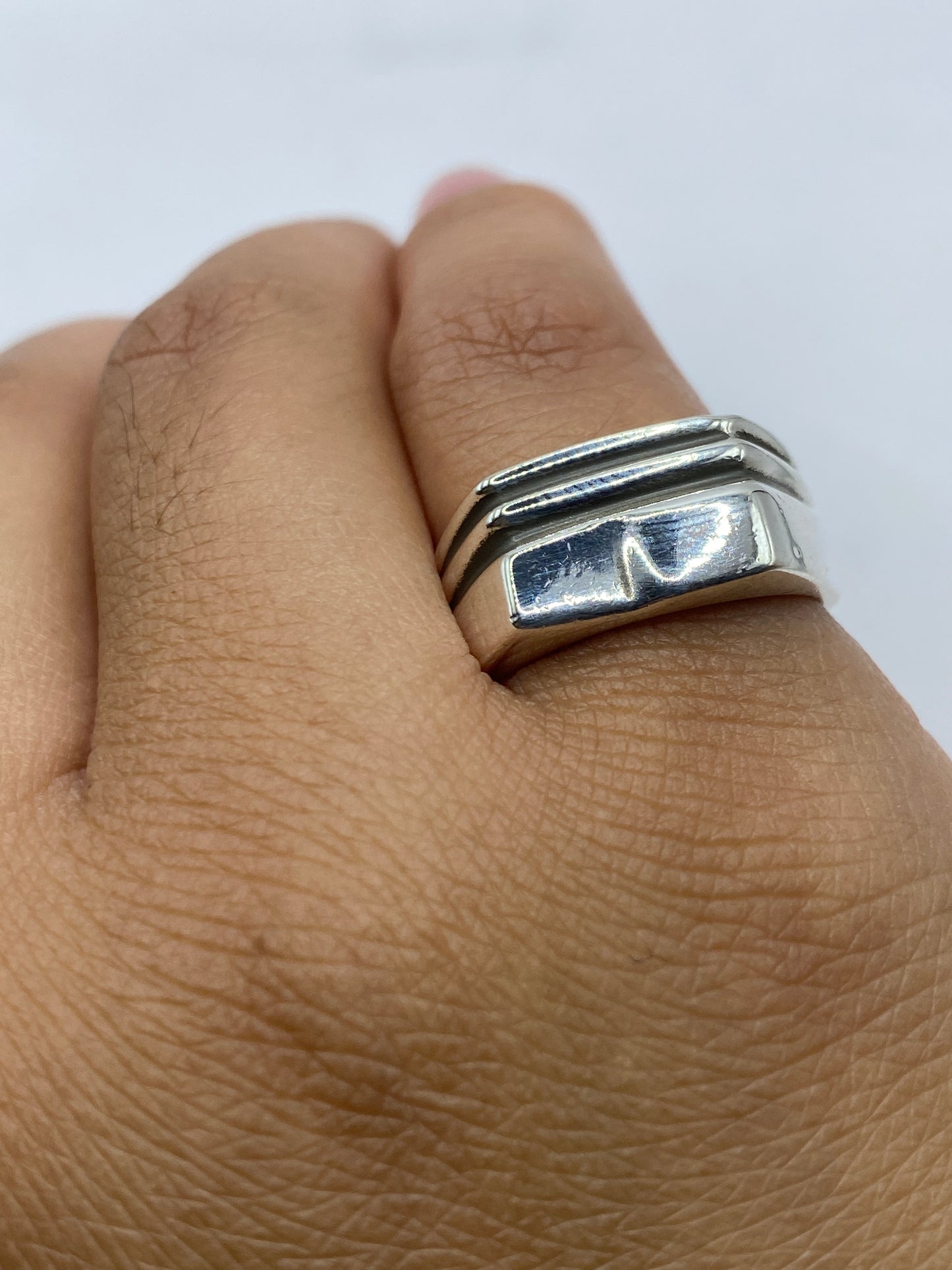 Anillo en la mano de un hombre mostrando peso y presencia del metal macizo