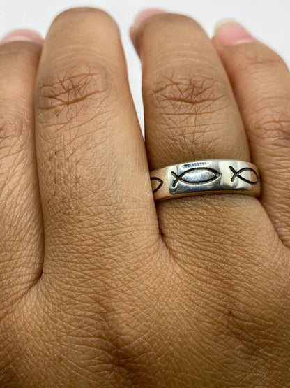 Anillo de peces en la mano mostrando pulido brillante y tallado artesanal