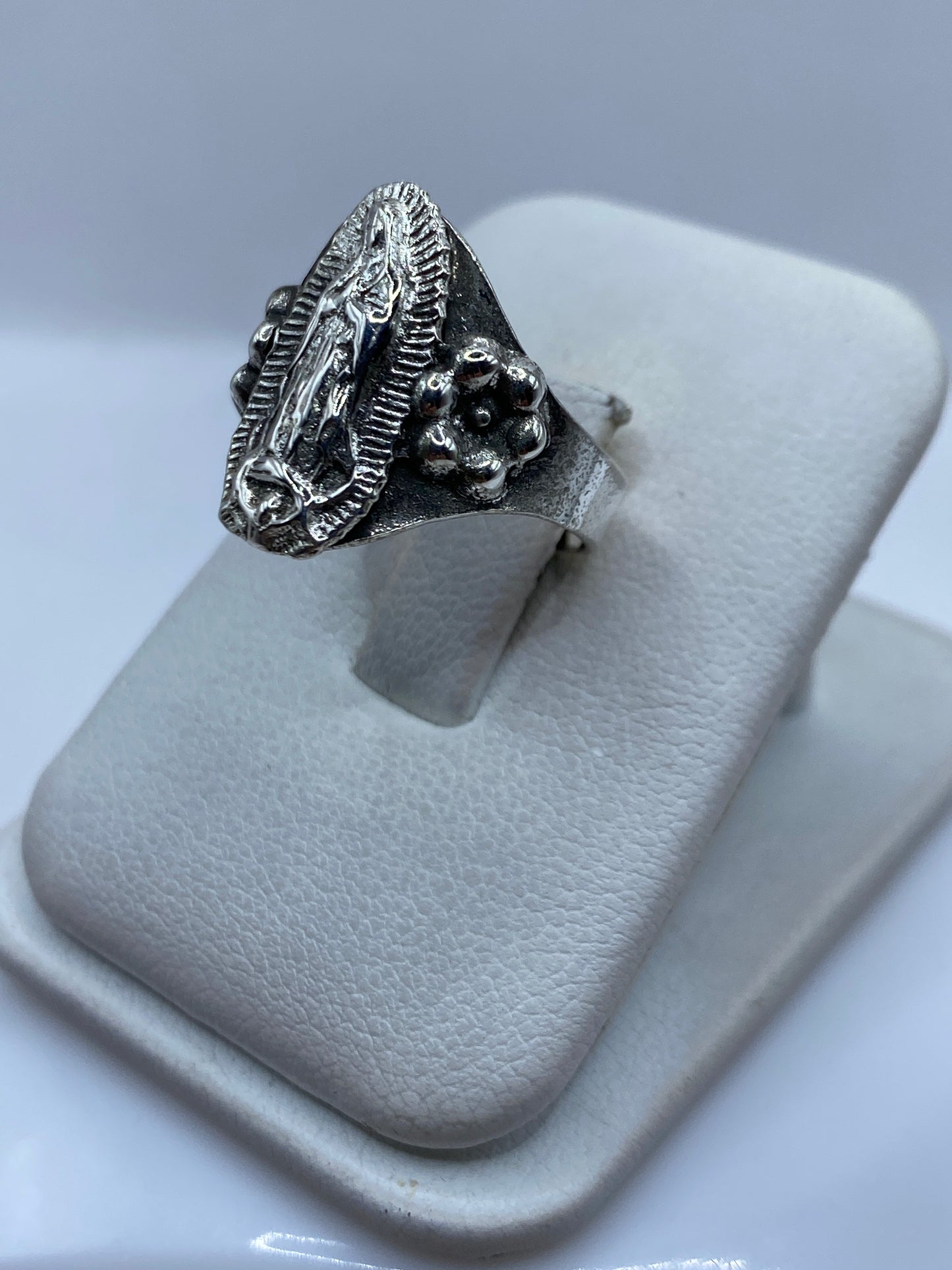 Detalle lateral del anillo religioso mostrando los elementos prehispánicos del diseño
