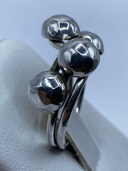 Detalle del anillo en mano femenina mostrando el acabado espejo de las esferas