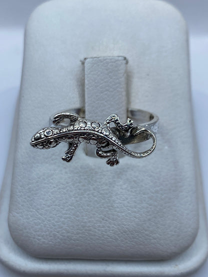 Anillo de plata artesanal con figura de iguana en relieve, sobre estuche blanco