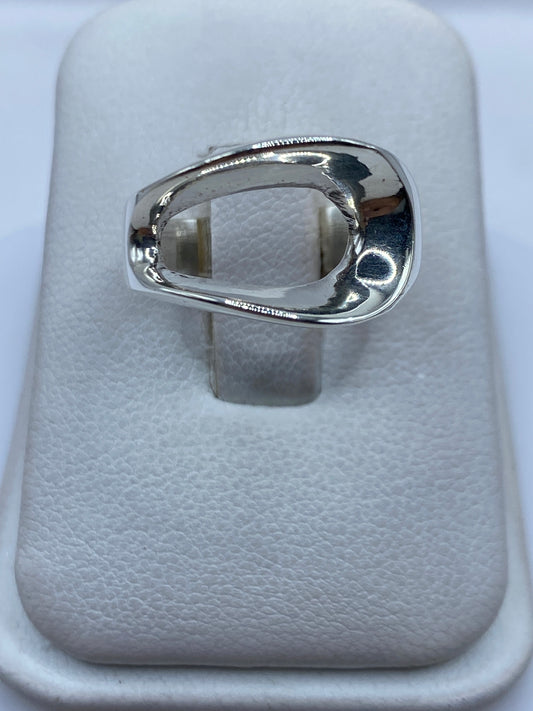 Anillo de plata solitario pulido en la mano de una mujer, mostrando su forma ovalada minimalista