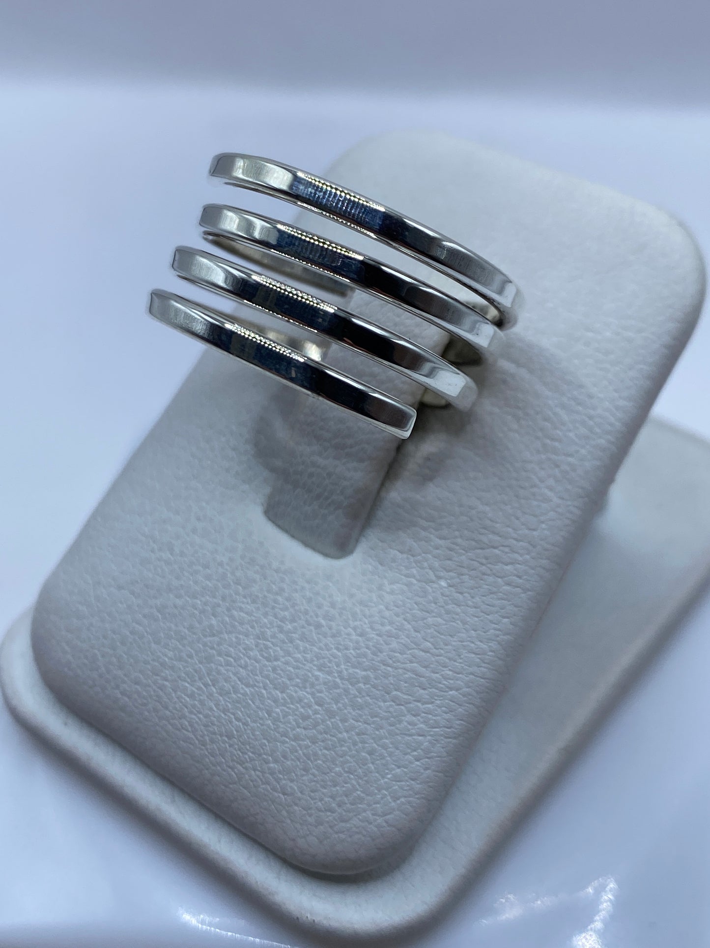 Bandas de plata minimalistas en la mano, mostrando el diseño liso y pulido