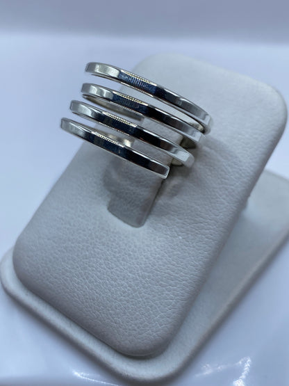 Bandas de plata minimalistas en la mano, mostrando el diseño liso y pulido