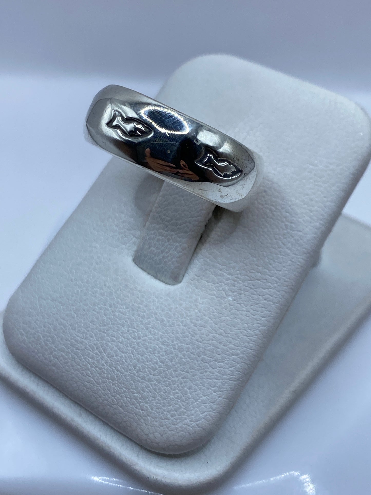 Anillo banda de plata en dedo mostrando el acabado espejo y el sello .925