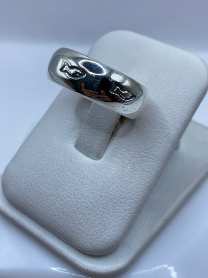 Anillo banda de plata en dedo mostrando el acabado espejo y el sello .925