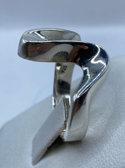 Anillo de plata puesto en dedo, mostrando el acabado brillante y minimalista