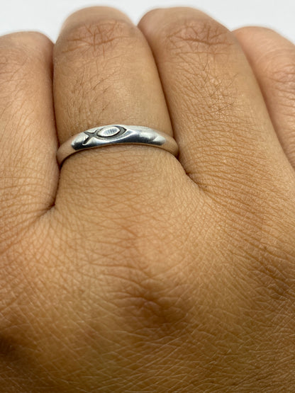 Anillo de plata minimalista sobre fondo blanco mostrando acabado pulido