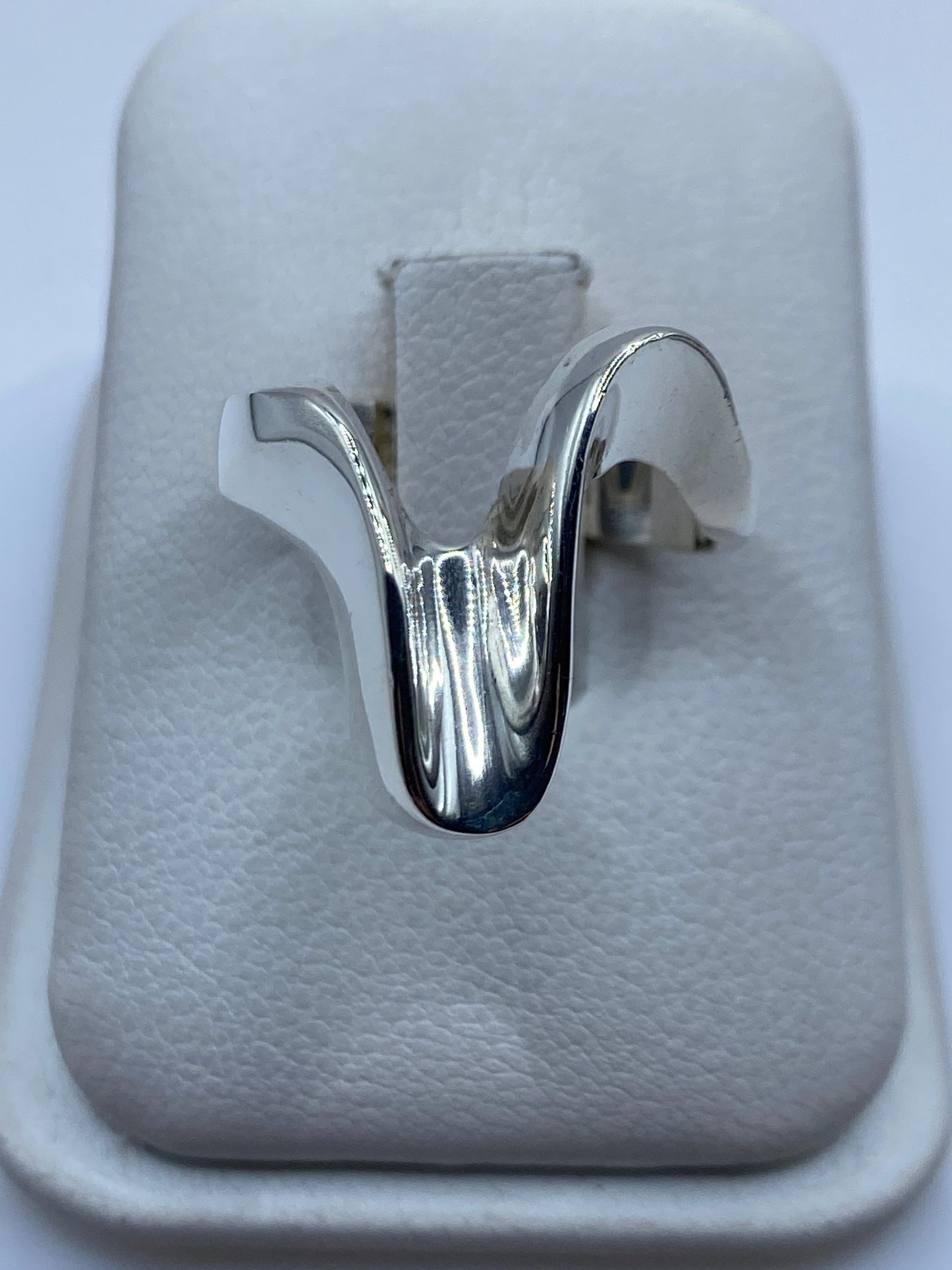 Anillo escultural de plata .925 en caja blanca, vista frontal del volumen orgánico