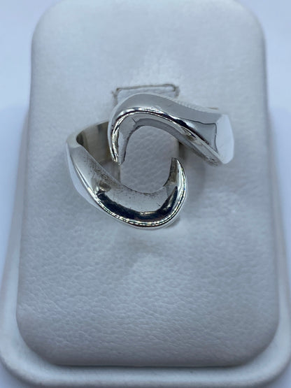 Anillo de plata minimalista liso en la mano de una persona, mostrando su acabado pulido