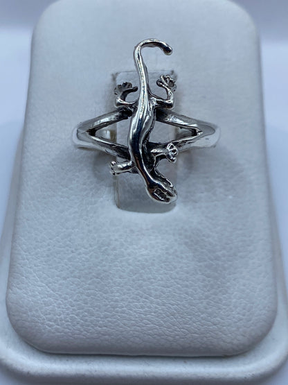 Anillo de plata con figura de serpiente escultural, vista frontal sobre almohadilla blanca