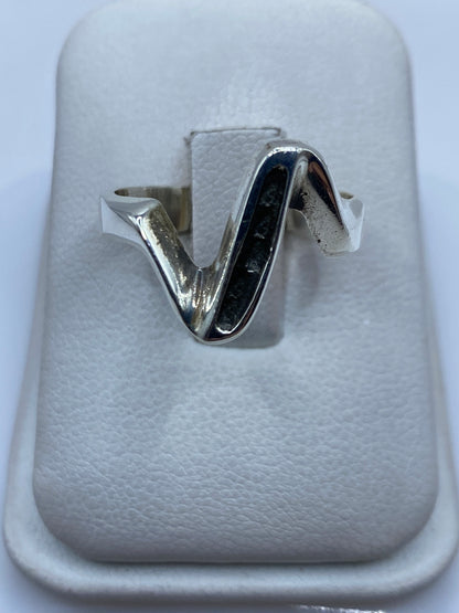 Anillo de plata minimalista en forma de V sobre estuche blanco, vista frontal