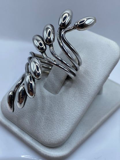 Anillo de plata flores naturales puesto en la mano mostrando el pulido espejo