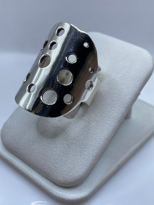 Detalle lateral del anillo mostrando la banda maciza y el patrón de perforaciones geométricas