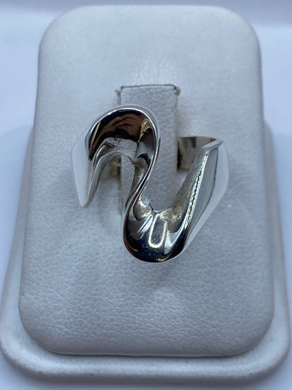 Anillo de plata macizo con diseño orgánico minimalista en la mano de una mujer
