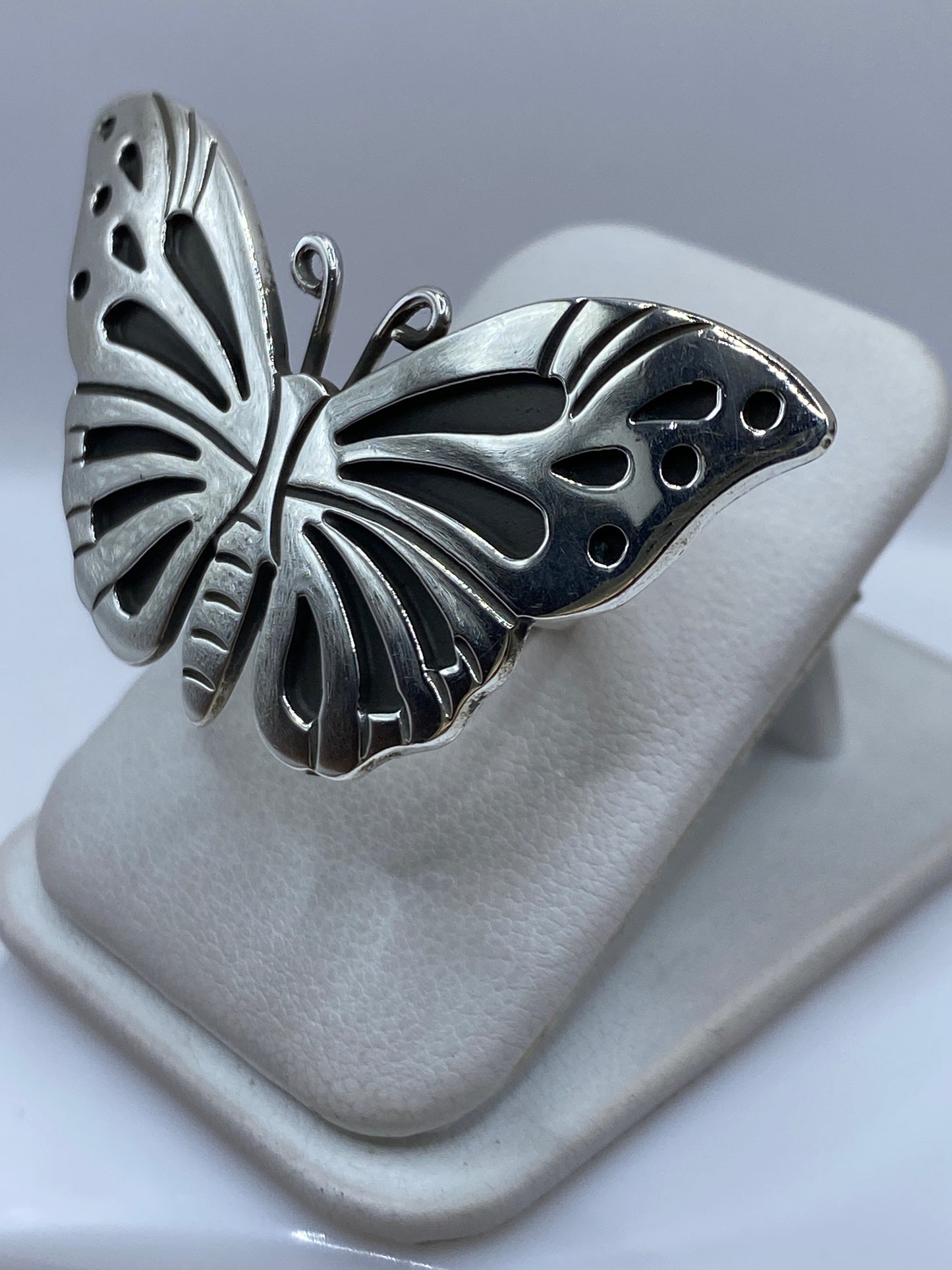 Detalle lateral del anillo mariposa mostrando las alas en relieve sobre dedo
