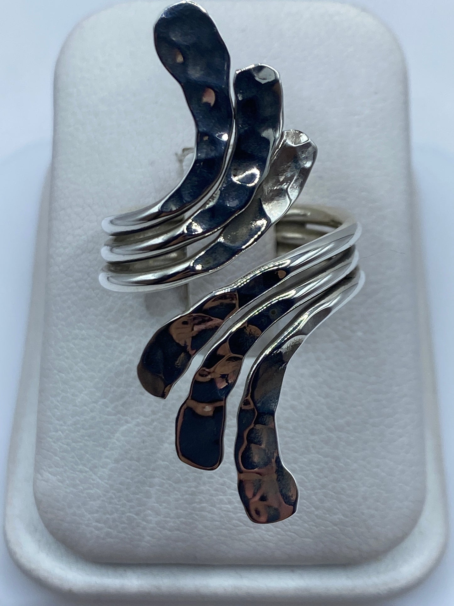 Anillo de plata calado ajustable con diseño geométrico entrelazado en dedo de mujer
