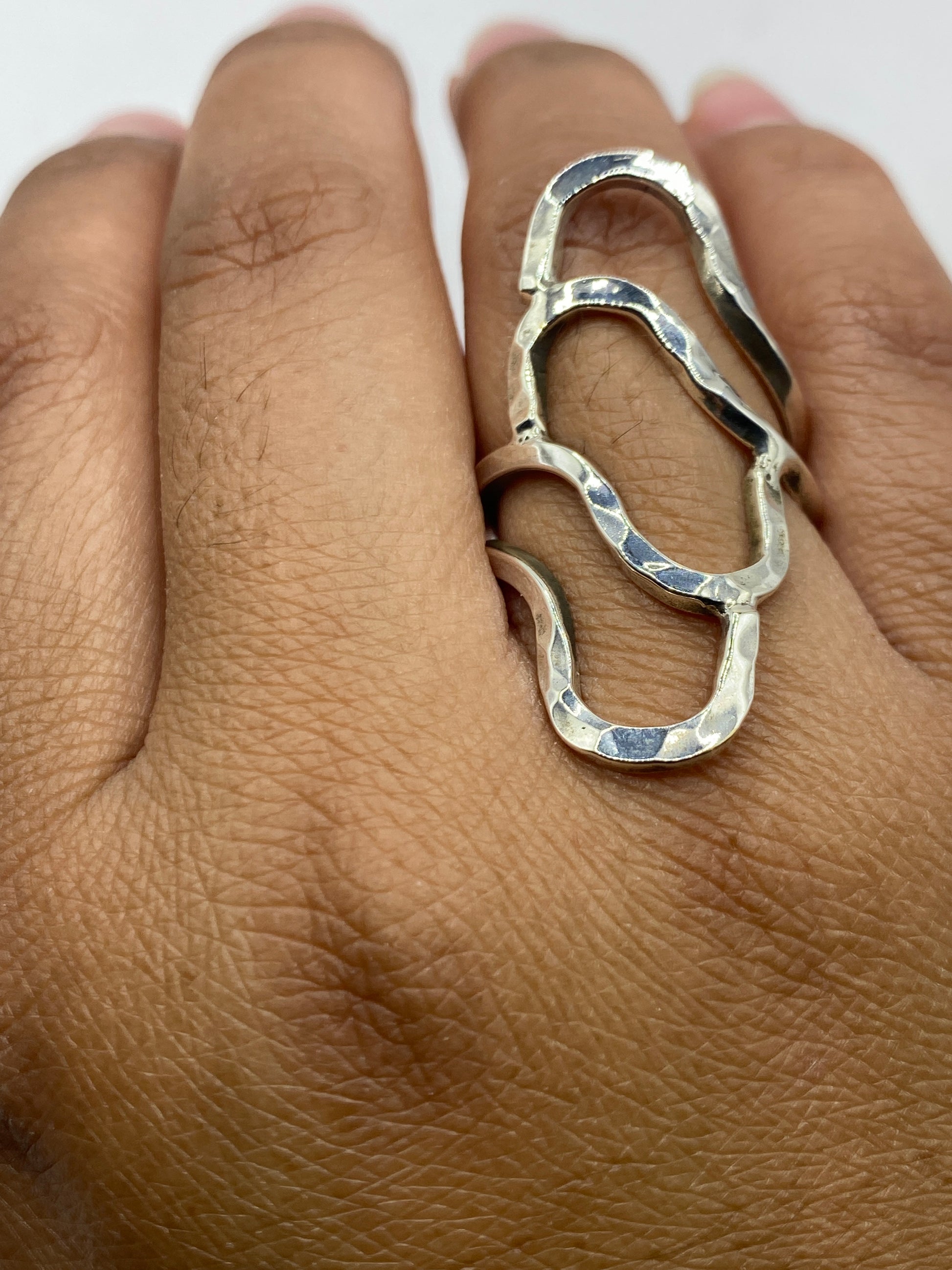 Anillo sobre dedo mostrando el brillo del pulido y los vacíos del calado