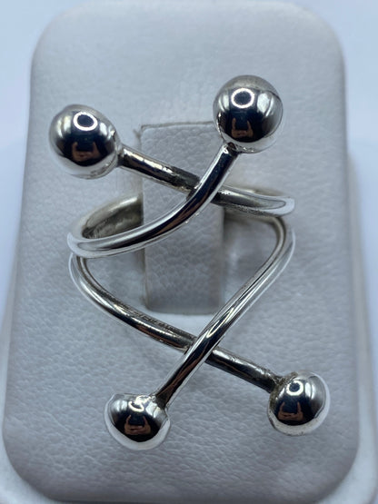 Anillo ajustable de plata .925 con eslabones y esferas sobre almohadilla blanca, vista superior