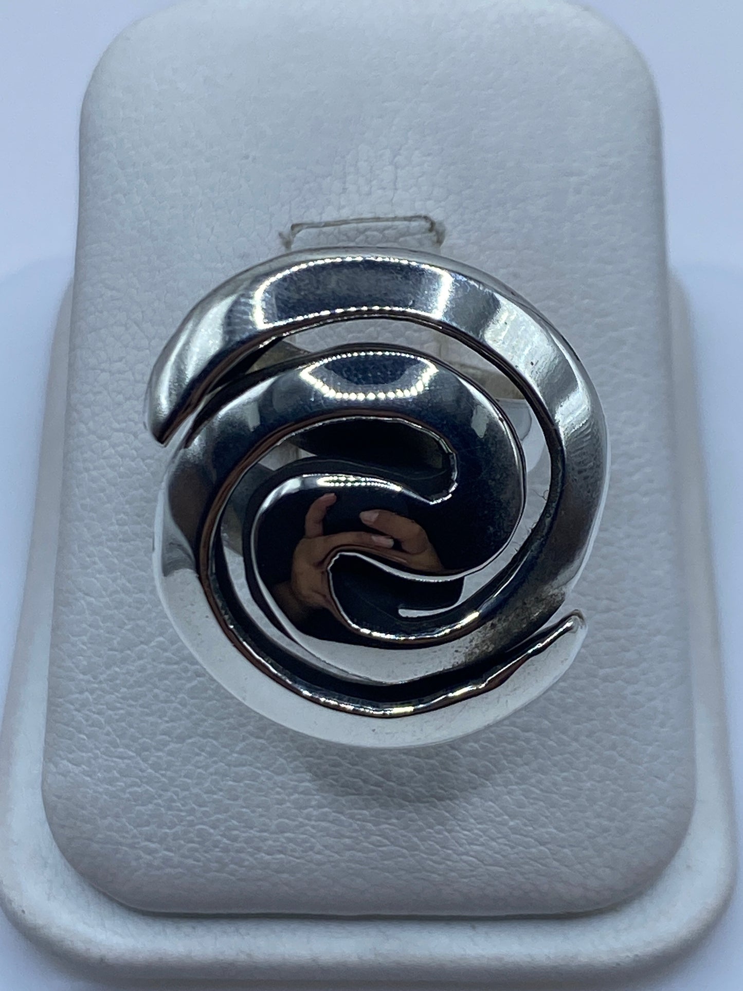 Anillo de plata cartoneado ajustable con espiral 3D giratoria en la mano de una mujer