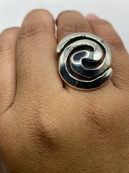 Anillo sobre fondo gris mostrando el movimiento giratorio y la estructura escultural