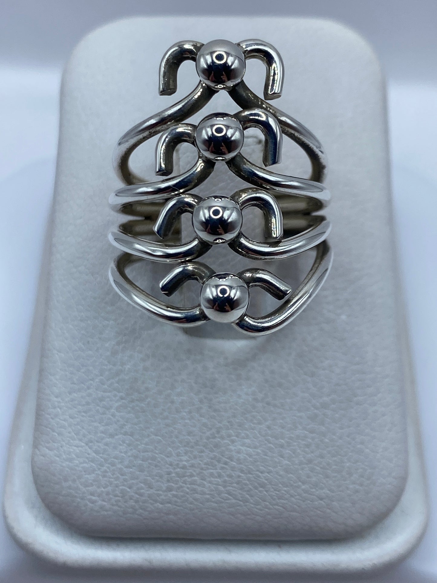 Anillo de plata en calado con motivos geométricos escultóricos en la mano de una mujer