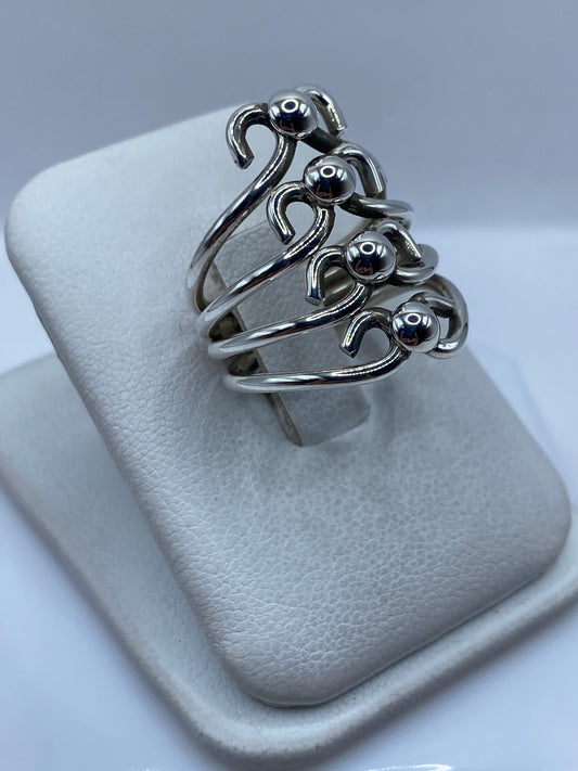 Vista lateral del anillo de plata calado mostrando la profundidad del diseño cortado